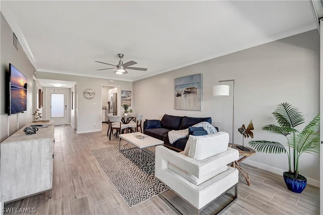 living room with ceiling fan and ornamental molding