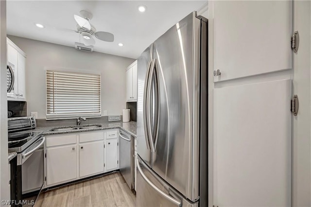 kitchen with ceiling fan, sink, stainless steel appliances, light hardwood / wood-style flooring, and white cabinets