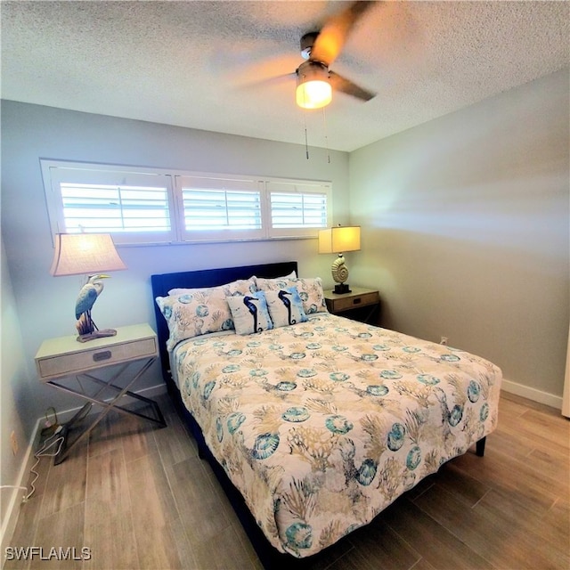 bedroom with multiple windows, ceiling fan, and hardwood / wood-style floors