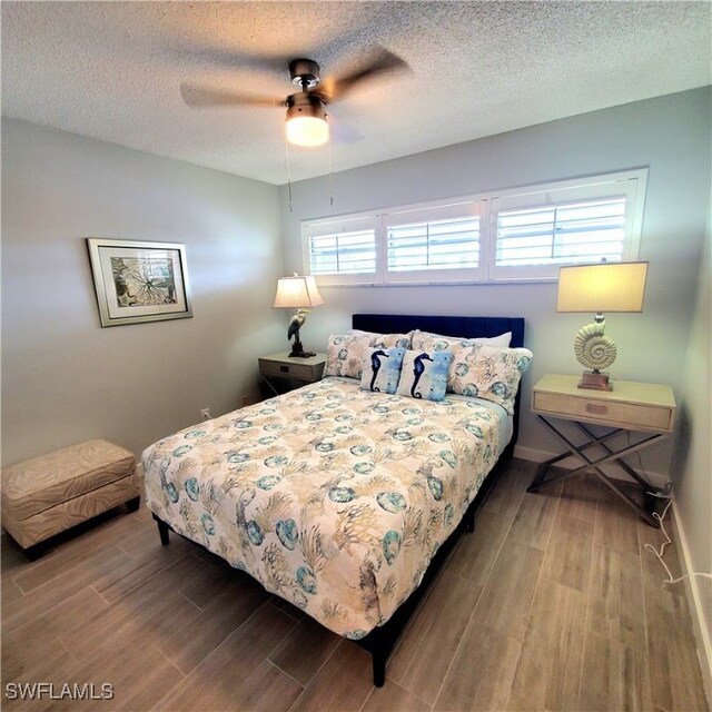 bedroom featuring hardwood / wood-style floors, ceiling fan, and a textured ceiling