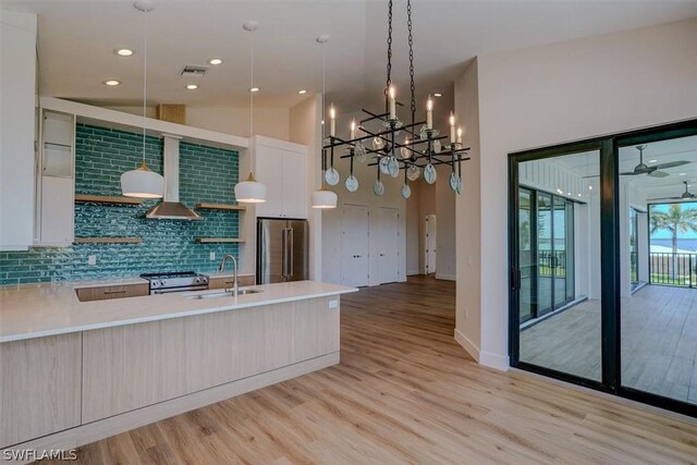 kitchen with pendant lighting, sink, tasteful backsplash, white cabinetry, and stainless steel appliances