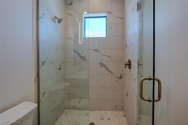 bathroom with a marble finish shower and toilet