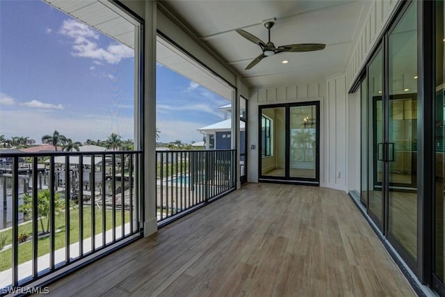 unfurnished sunroom featuring a ceiling fan