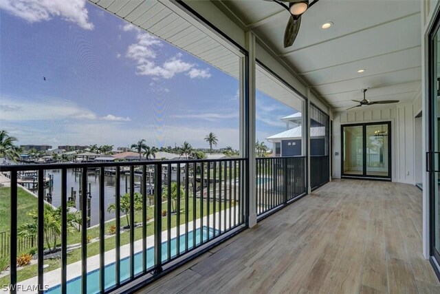 balcony featuring ceiling fan and a water view