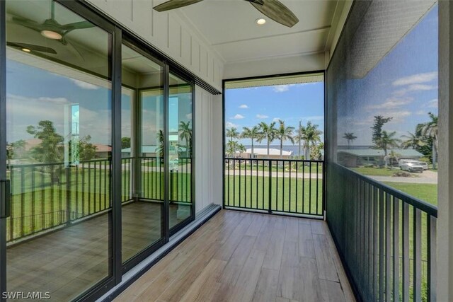 unfurnished sunroom with ceiling fan