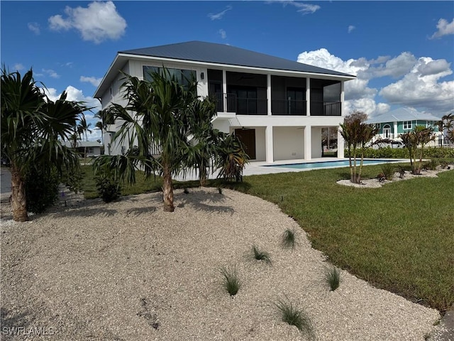 back of property with a sunroom and a yard