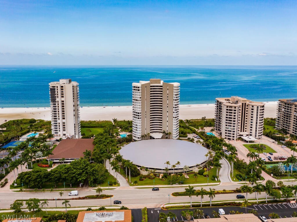 drone / aerial view with a water view and a beach view