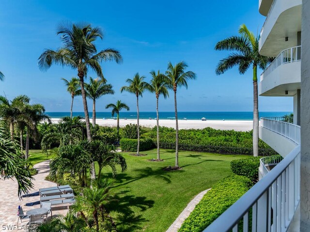 surrounding community featuring a water view, a beach view, and a lawn