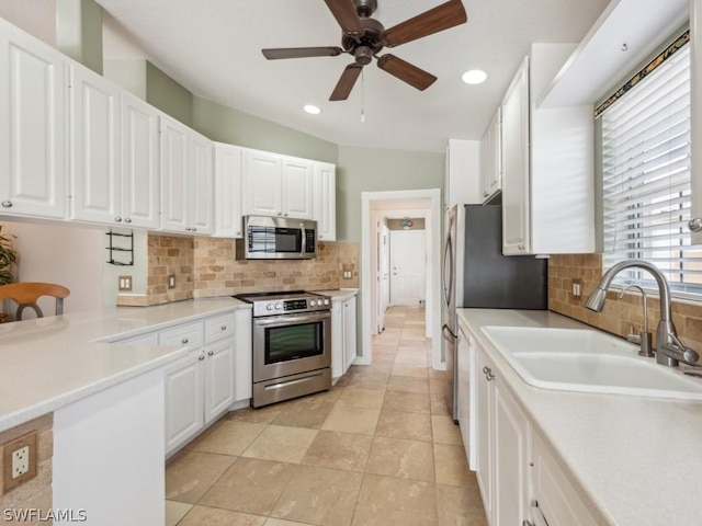 kitchen featuring white cabinets, ceiling fan, sink, and stainless steel appliances