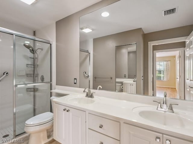 bathroom featuring tile patterned floors, toilet, vanity, and walk in shower