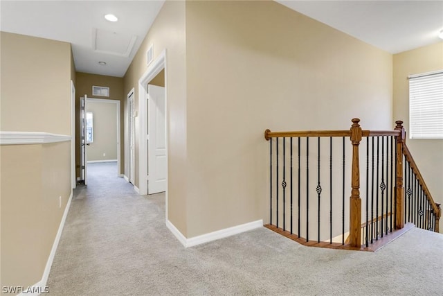 corridor featuring carpet flooring, an upstairs landing, and baseboards