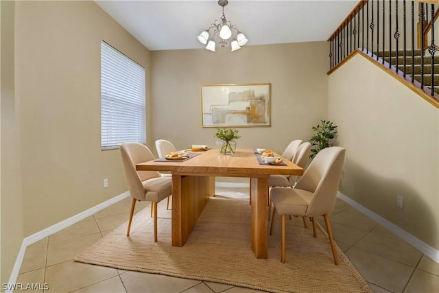 dining space with light tile patterned flooring, a notable chandelier, baseboards, and stairs