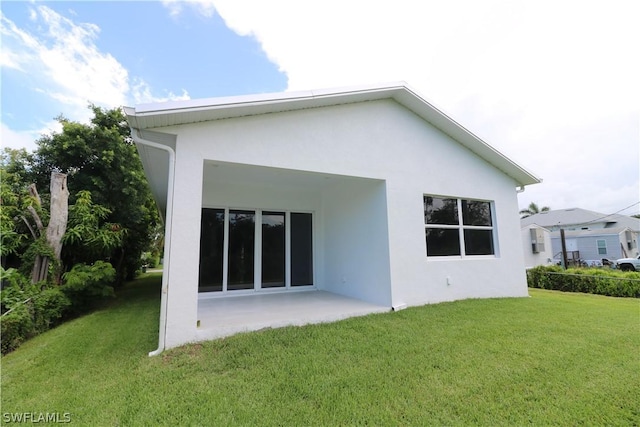 back of property featuring a yard and a patio