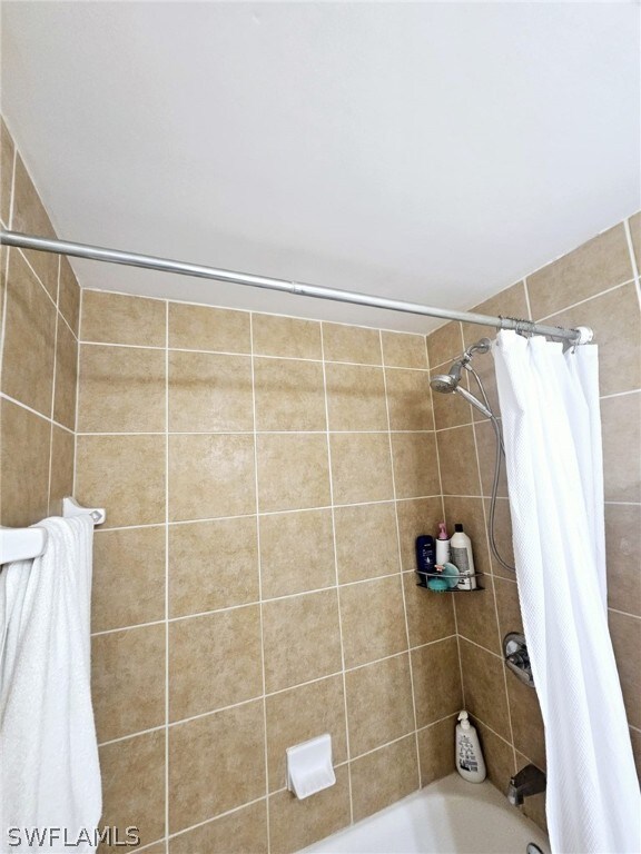 bathroom with shower / bathtub combination with curtain