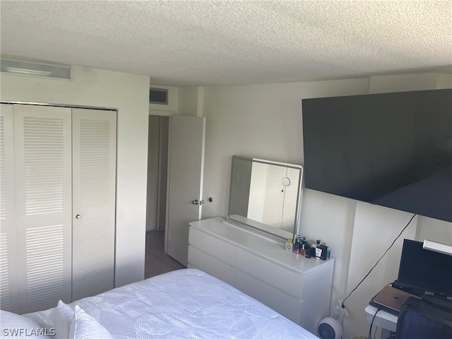 tiled bedroom with a closet and a textured ceiling