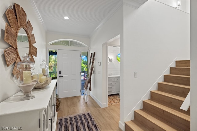 entrance foyer featuring crown molding and light hardwood / wood-style floors