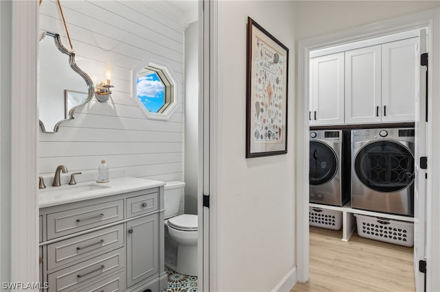 bathroom with vanity, toilet, separate washer and dryer, and wood-type flooring