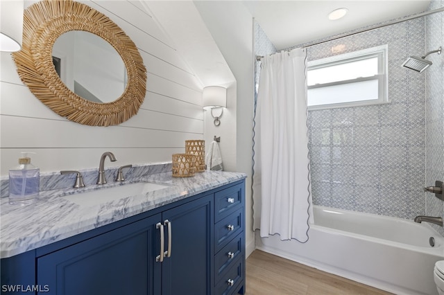 bathroom featuring hardwood / wood-style floors, shower / bath combination with curtain, and vanity