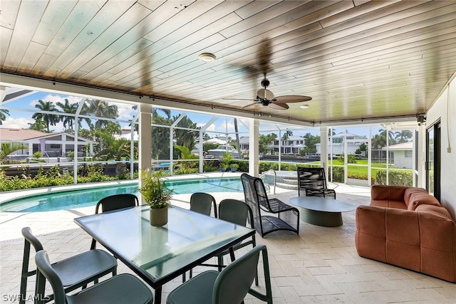 sunroom featuring ceiling fan and wood ceiling