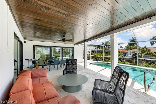 exterior space featuring glass enclosure and ceiling fan