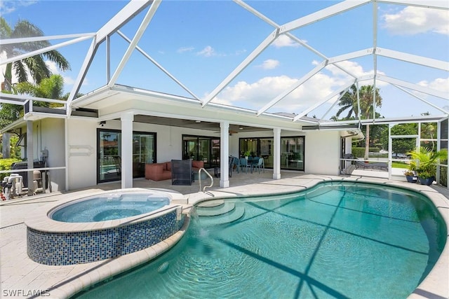 view of swimming pool with glass enclosure, ceiling fan, a patio, and an in ground hot tub