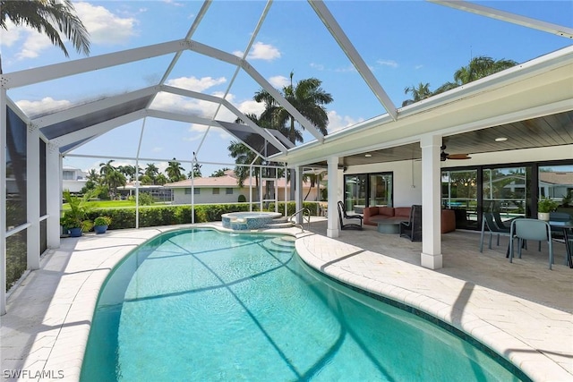 view of swimming pool with an in ground hot tub, a lanai, an outdoor living space, ceiling fan, and a patio