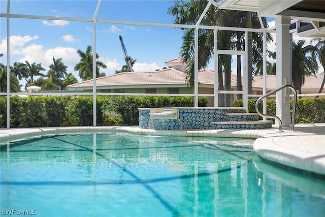 view of pool featuring pool water feature, a patio area, and a lanai