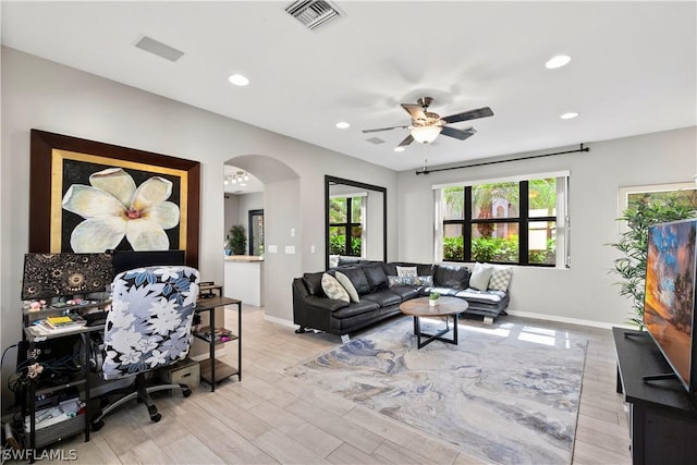 living room featuring a wealth of natural light, ceiling fan, and light hardwood / wood-style floors