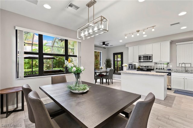 dining area with ceiling fan and sink