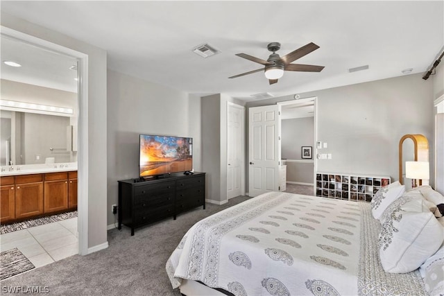 carpeted bedroom with ceiling fan, sink, and ensuite bathroom