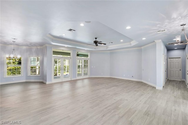 unfurnished living room with a raised ceiling, french doors, light hardwood / wood-style flooring, and ornamental molding