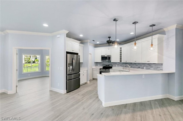 kitchen featuring kitchen peninsula, stainless steel appliances, ceiling fan, white cabinetry, and hanging light fixtures