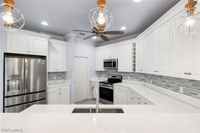 kitchen with pendant lighting, white cabinets, sink, and stainless steel appliances