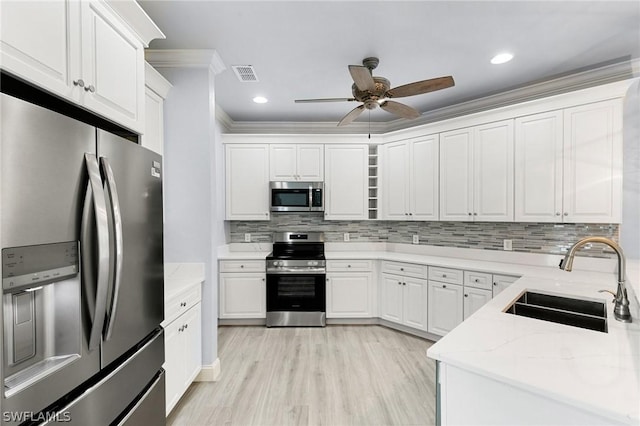 kitchen featuring light stone counters, sink, white cabinets, and stainless steel appliances