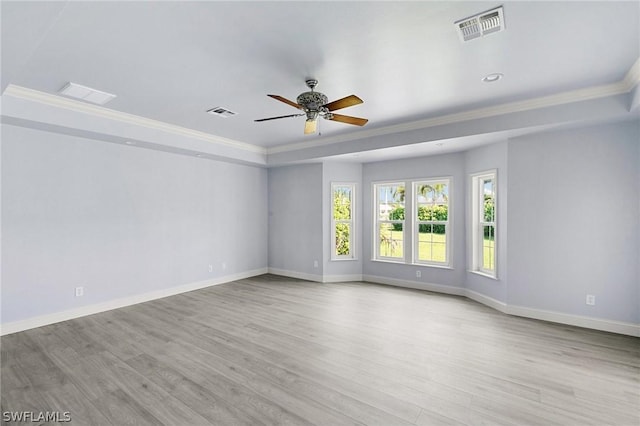 spare room with a raised ceiling, ceiling fan, light hardwood / wood-style flooring, and ornamental molding