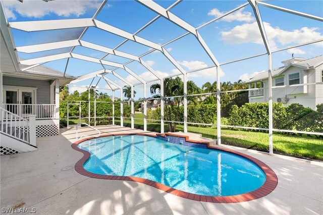 view of swimming pool featuring a patio and a lanai