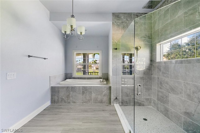 bathroom featuring separate shower and tub, plenty of natural light, and a notable chandelier