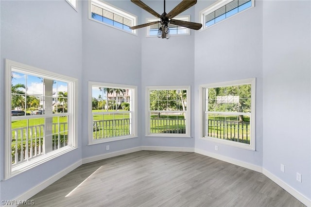 unfurnished sunroom featuring ceiling fan