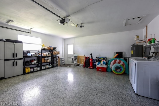 garage with a garage door opener, washing machine and dryer, and water heater