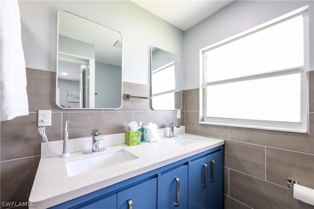 bathroom with vanity and tile walls