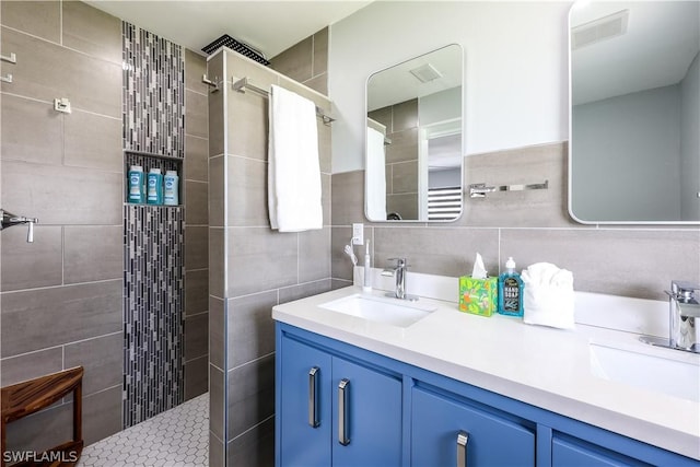 bathroom with vanity, tasteful backsplash, tile walls, and tiled shower