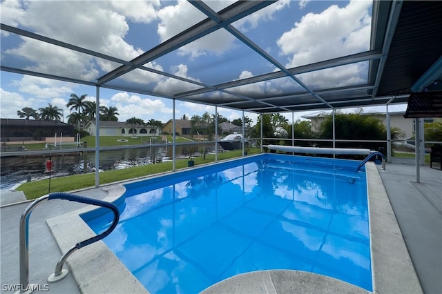 view of swimming pool featuring glass enclosure and a water view