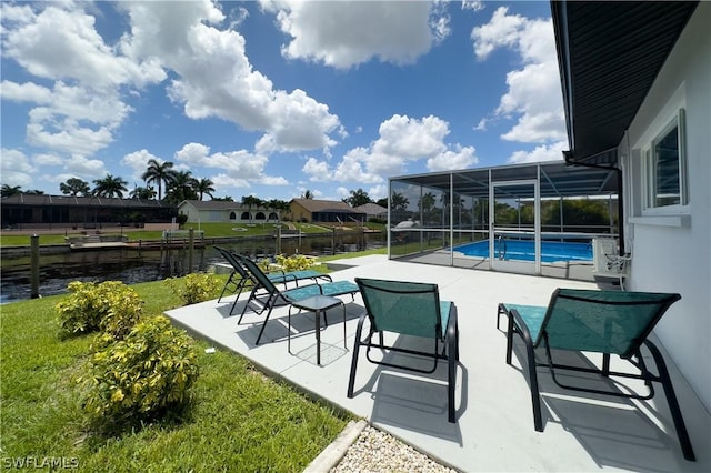 view of pool featuring a patio, a water view, glass enclosure, and a lawn