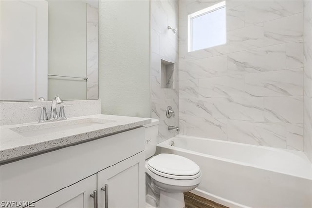 full bathroom featuring tiled shower / bath combo, toilet, and vanity