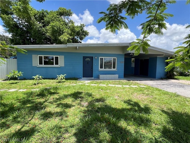 ranch-style house with a front yard and a carport