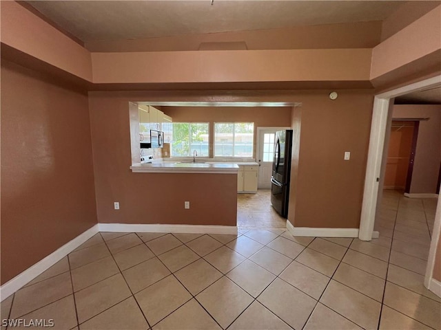 spare room with sink and light tile patterned floors