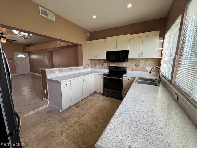 kitchen with kitchen peninsula, sink, white cabinets, and black appliances