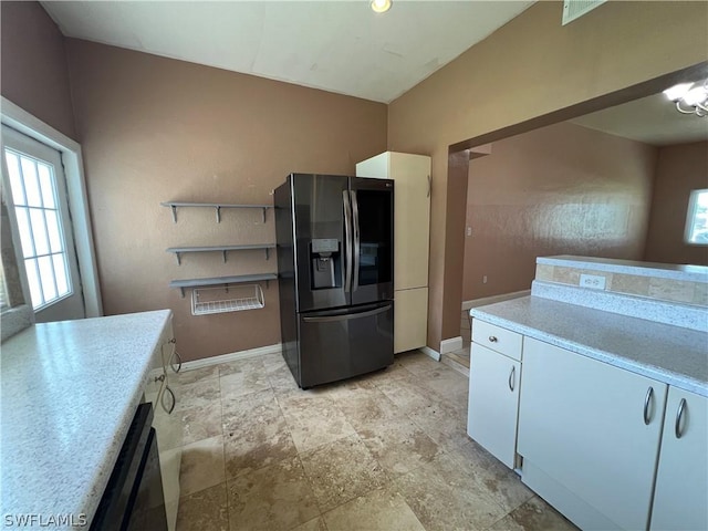 kitchen featuring dishwasher, stainless steel refrigerator with ice dispenser, and white cabinetry