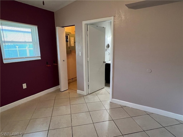 empty room with ceiling fan and light tile patterned flooring