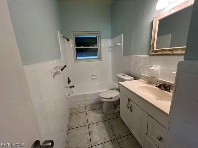 full bathroom with tile walls, vanity, tiled shower / bath combo, and toilet